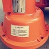 Orange construction hoist part on a concrete floor.