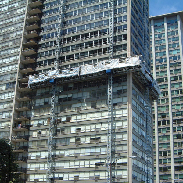 Plataforma escaladora de mástil de construcción de dos mástiles suspendida en el costado de un edificio de gran altura.