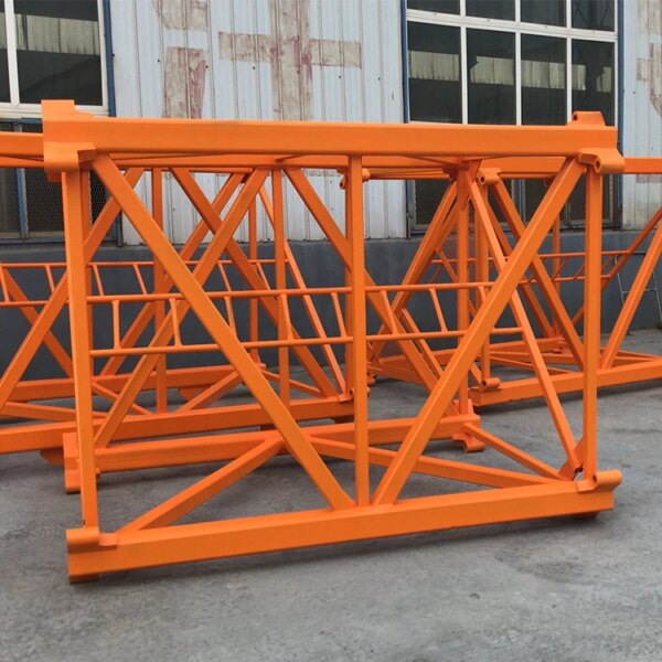 Oranje metalen steigerconstructies en een IHURMO 6 Ton 40 m Hoogte TC5013 QTZ80 torenkraan zijn op een betonnen vloer geplaatst tegen een industriële achtergrond.