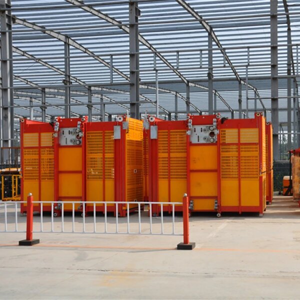 Entrepôt industriel avec unités de stockage rouges et jaunes et un ascenseur de construction à double cage.