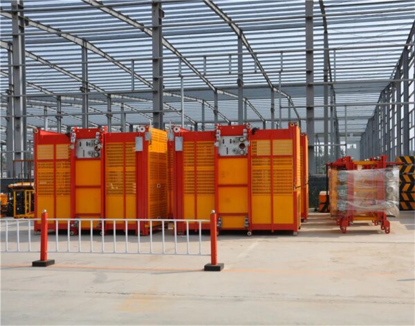 Industrial warehouse with yellow and red storage containers and a Double Cage Hoist for Building Construction.