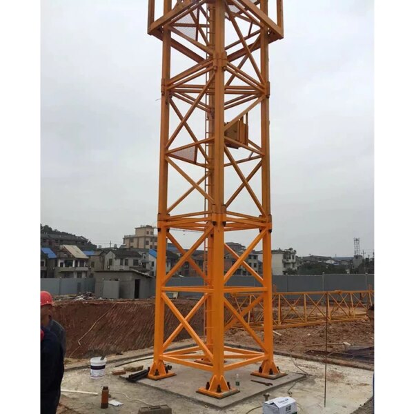 A tall, yellow IHURMO 5T TC5011 QTZ63 tower crane erected on a construction site with buildings in the background.