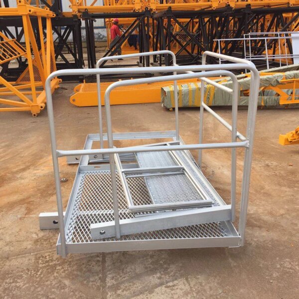 Sturdy metal access platform with safety rails, positioned on a concrete ground at an industrial site near a Hot sale china brand self erecting construction lift hammerhead tower crane.