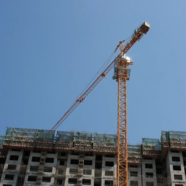 IHURMO CE certificate self-erecting Qtz80 5612 6T construction hammerhead tower crane at a construction site with an unfinished building in the background.