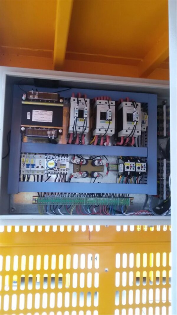 An electrical control panel with circuit breakers and wired connections is essential for the Double Cage Hoist used in building construction.