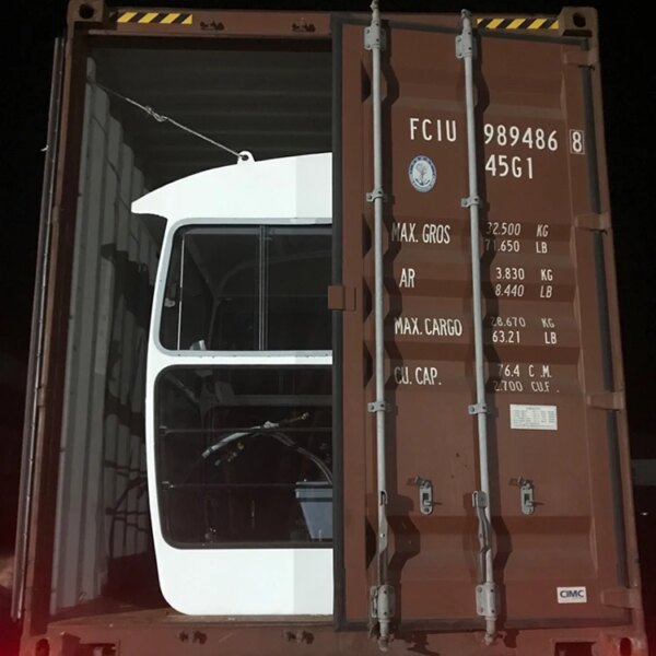 Cabina camionului care iese dintr-un container de marfă cu macara turn IHURMO 5T TC5011 QTZ63 pe timp de noapte.