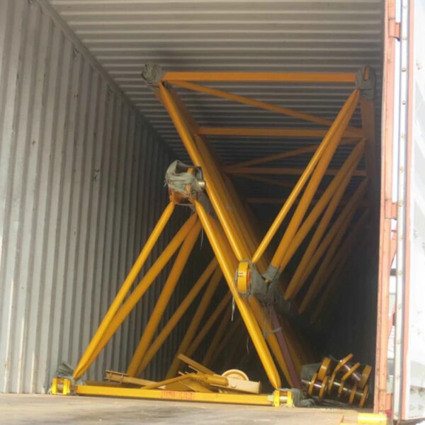 Collapsed yellow scaffolding inside a shipping container with a building construction pt6013-8 topless tower crane nearby.