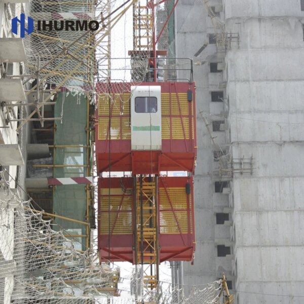 Konstruksi rak sangkar ganda dan lift pinion hoist naik di samping bangunan yang sedang dibangun.