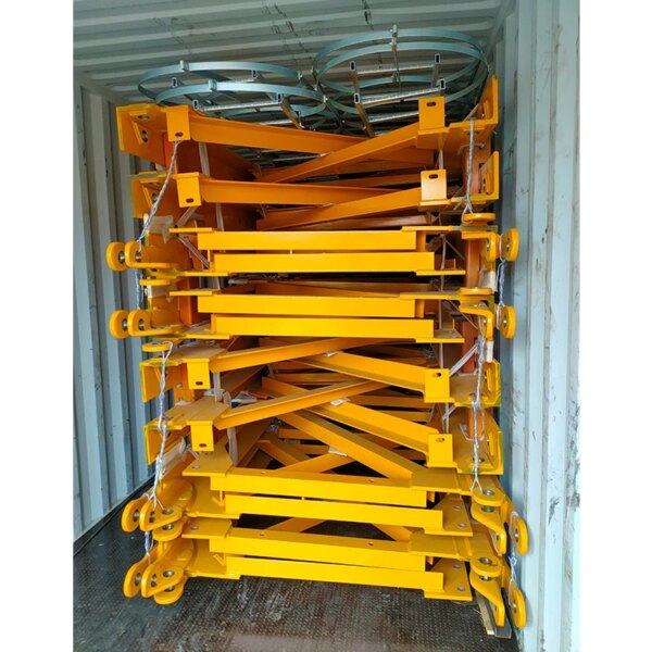 Sentence with product name: Stacked yellow metal construction braces inside a shipping container supported by a China IHURMO 8T luffing jib tower crane.