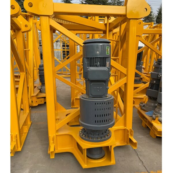 Pièce de machinerie industrielle, probablement un moteur ou une pompe pour une grue à tour IHURMO 5T TC5011 QTZ63, montée sur un châssis en métal jaune.