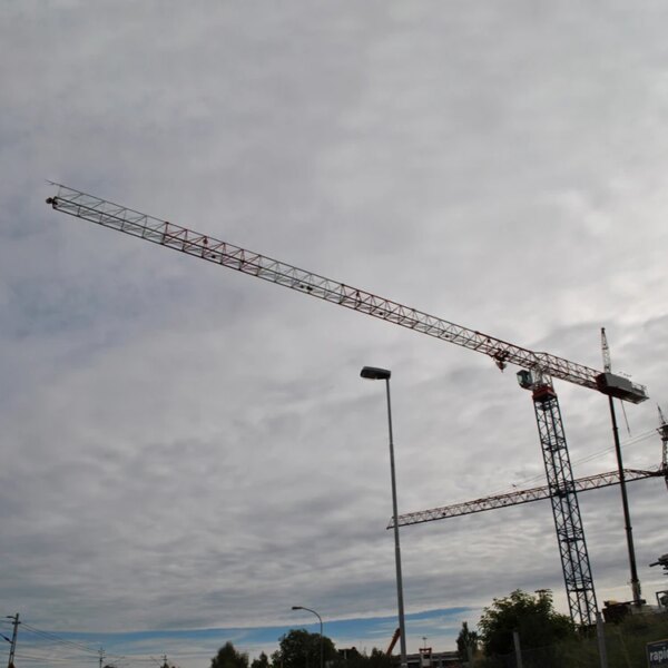 Due gru a torre piatte IHURMO cinesi contro un cielo nuvoloso.