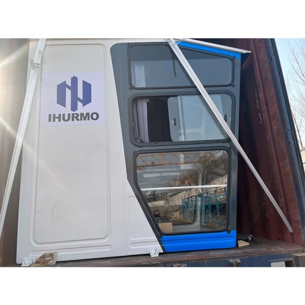 Unidad modular prefabricada cargada dentro de un contenedor marítimo mediante grúa torre flat-top de construcción IHURMO de 60 m, 75 m, 80 m y 100 m de altura para su transporte.