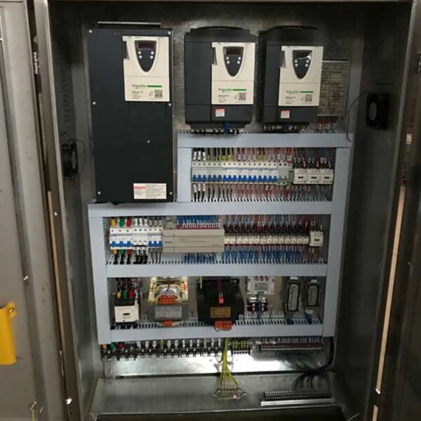 Um painel de controle elétrico industrial aberto para o guindaste de torre IHURMO CE QTZ125 TC6015 de 50 m de altura e 10 toneladas, com disjuntores, fiação e outros componentes elétricos.