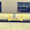 Yellow suspended platforms with "ihurmo" label in front of an industrial building in Russia.