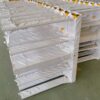 Stacks of wrapped metal parts on a platform in a warehouse.