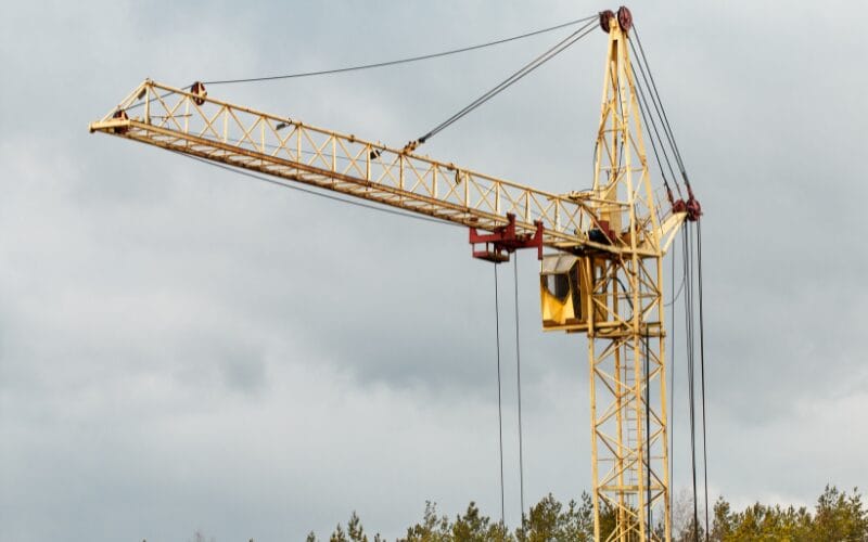 Gele torenkraan wordt opgericht tegen een bewolkte lucht.