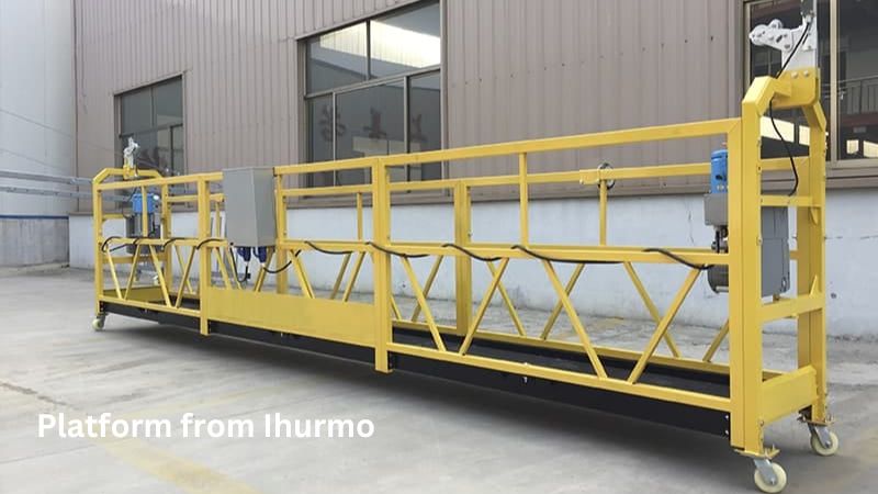 Uma plataforma Ihurmo amarela confiável, com guarda-corpos e componentes elétricos, é posicionada para manutenção industrial segura e eficiente.