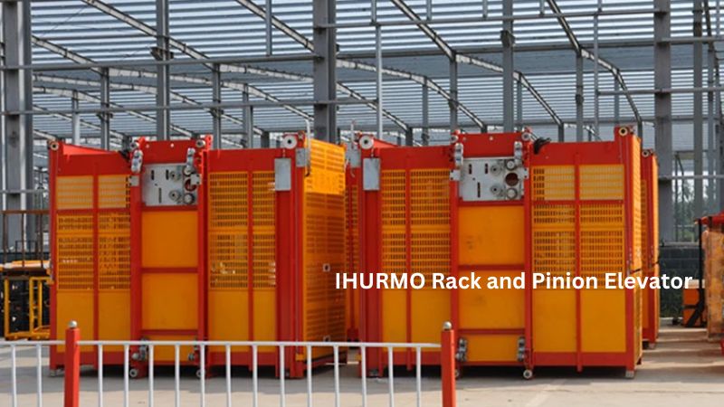 ลิฟต์แบบแร็คแอนด์พิเนียน IHURMO สีส้มและสีเหลืองสดใสจำนวน 4 ตัวตั้งเรียงรายอยู่ที่ไซต์ก่อสร้างที่มีโครงโลหะ