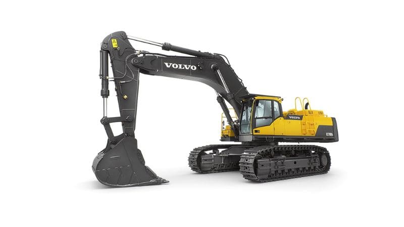 सफेद पृष्ठभूमि पर पटरियों पर चलने वाली, बड़ी बाल्टी वाली पीले और काले रंग की वोल्वो हाइड्रोलिक उत्खनन मशीन दिखाई गई है।.