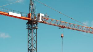 An image of a luffing crane featuring an extended jib, showcasing its lifting capabilities and structural design, used in construction projects for precise load handling.