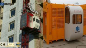 Elevator hoist for construction site with safety cage and control panel.