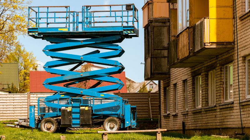 High-quality blue mobile scissor lift used for building maintenance and construction tasks. Equipped with safety rails and extendable platform for elevated work.