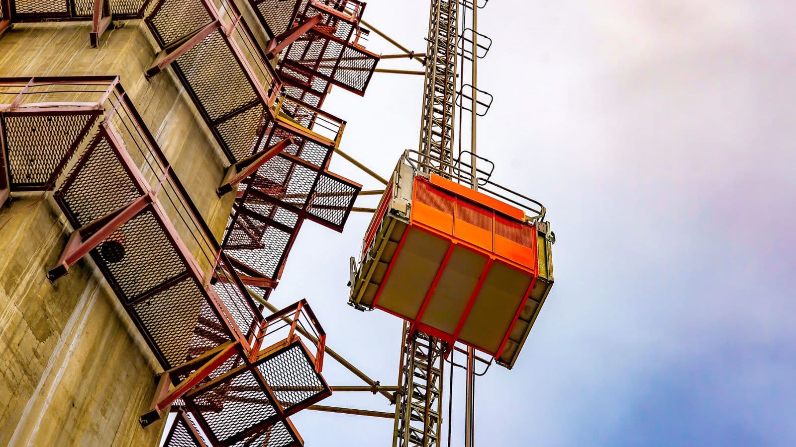 Construction hoist lift on a high-rise building under construction, showcasing safety features and structural design.